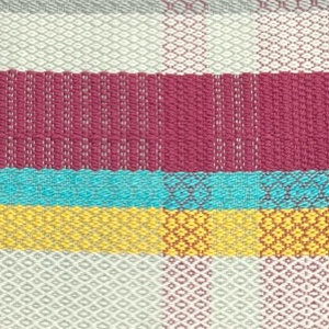 A brightly colored weaving done on a floor loom
